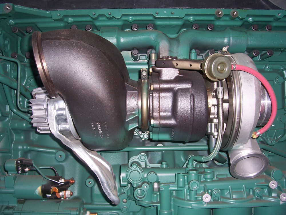 A turbocharger assembly on a diesel engine – tuners often modify ECU limits to safely push such turbos beyond factory boost pressure.